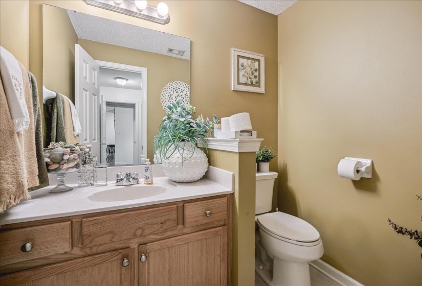 Bathroom featuring a vanity with light wood-finish cabinetry, an integrated sink, and a white countertop