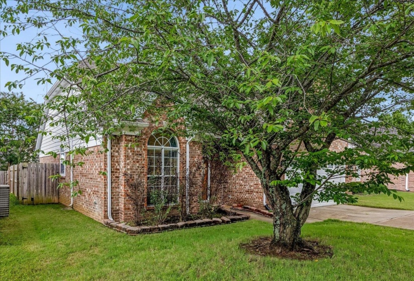 Brick exterior with white siding accents and an arched window