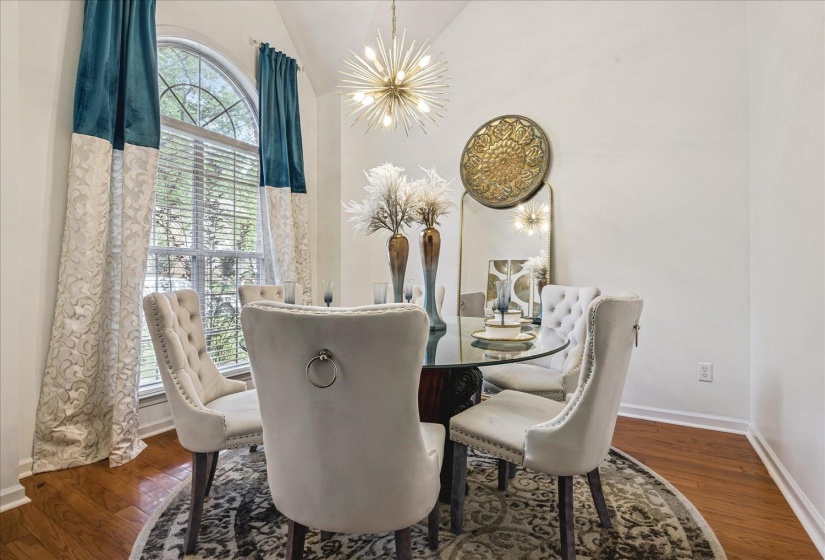 Dining area featuring hardwood flooring and a vaulted ceiling
