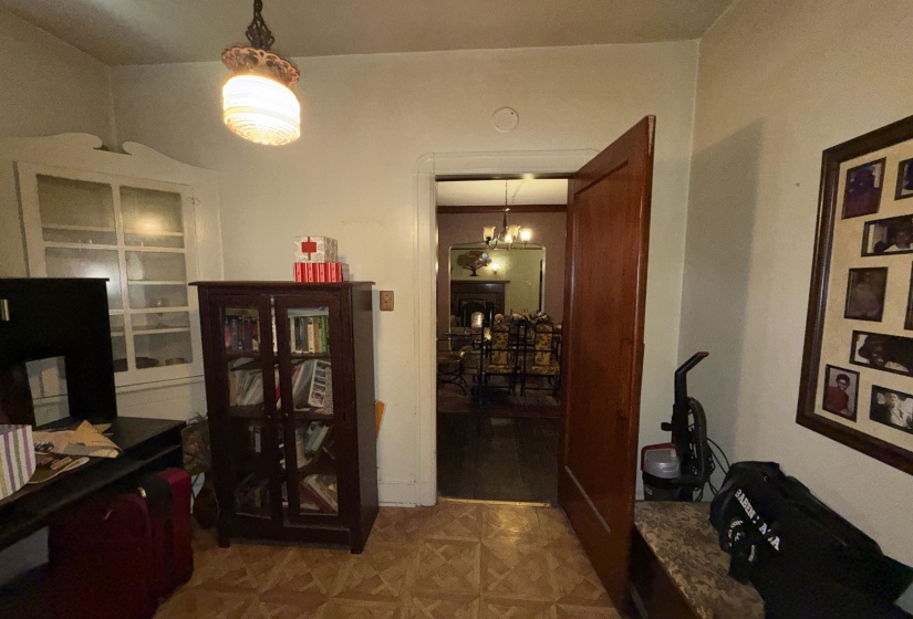 Archway entrance to formal dining area with dark wood flooring and chandelier