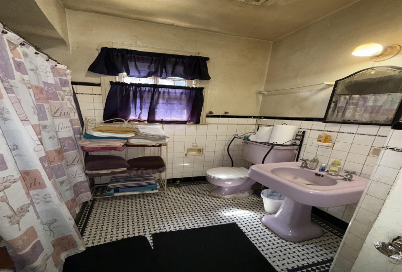Bathroom featuring a lavender pedestal sink and matching toilet