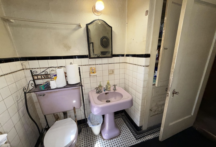 Bathroom featuring a pedestal sink, toilet, and wall-mounted mirror