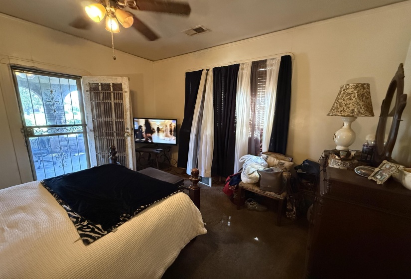 Bedroom featuring a ceiling fan with light fixture, carpeted flooring, and a window with blinds