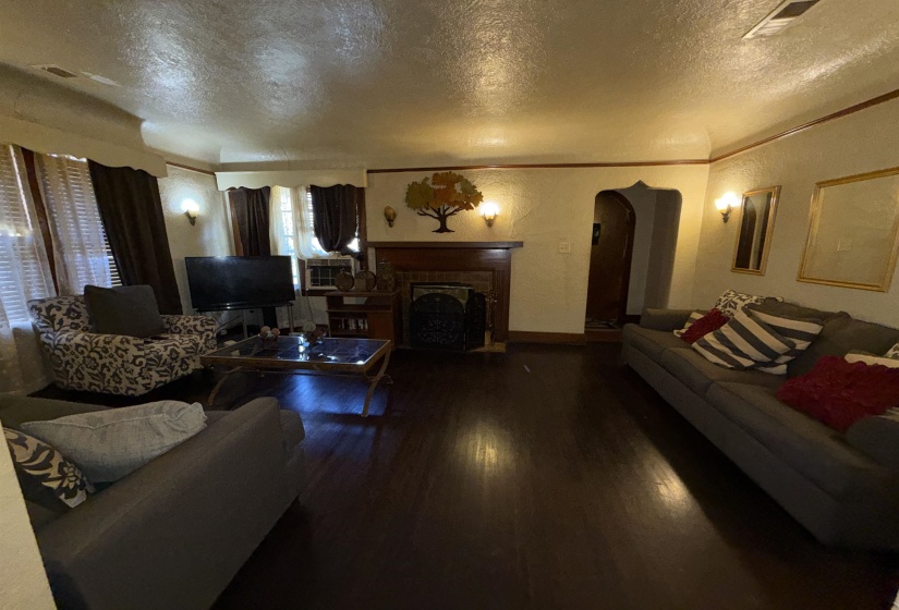 Living area featuring wood-finish flooring and a fireplace with a dark wood mantel