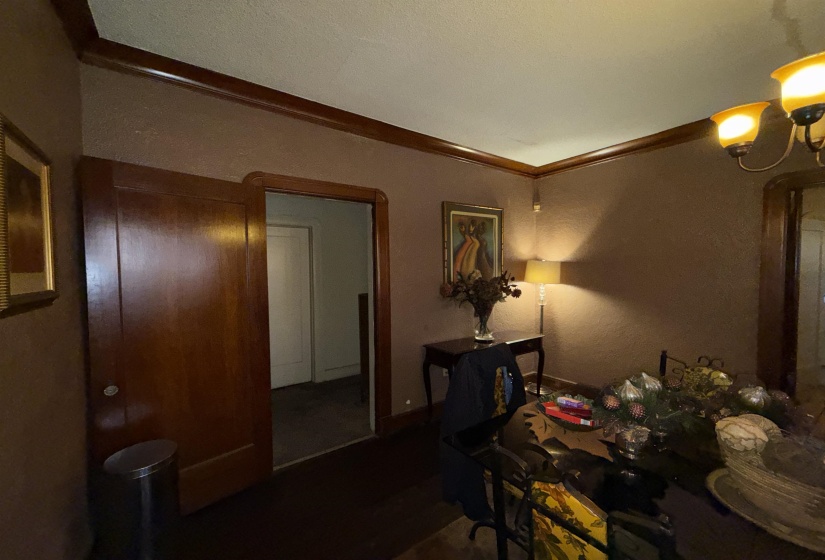 Wood-finish flooring, dark wood crown molding, and a solid wood door create a cohesive interior aesthetic