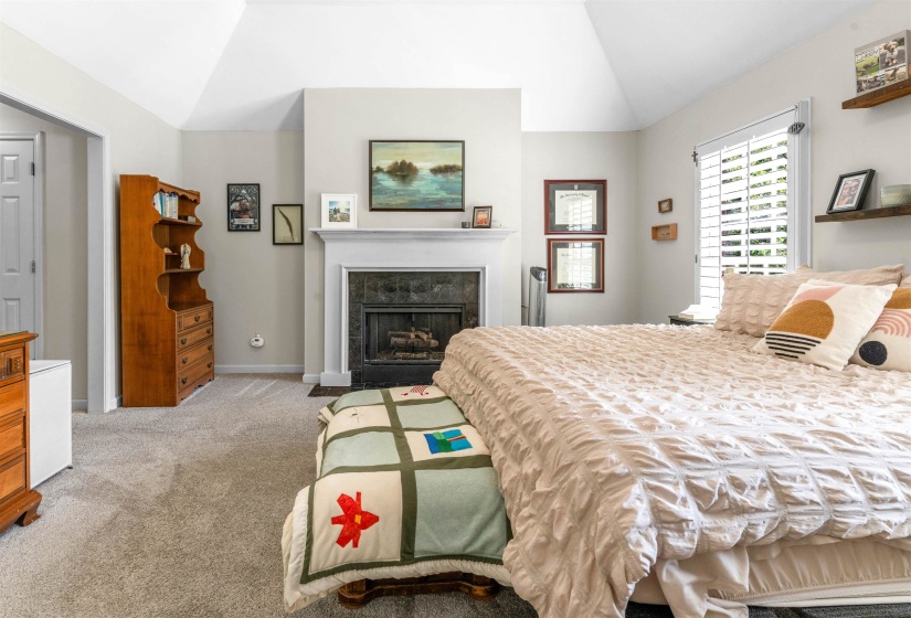 Vaulted ceiling with an integrated fireplace featuring a dark tile surround and a classic white mantel