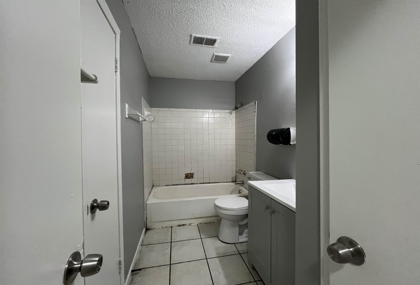 Full bathroom with vanity, tile patterned floors, a textured ceiling, and shower / tub combination