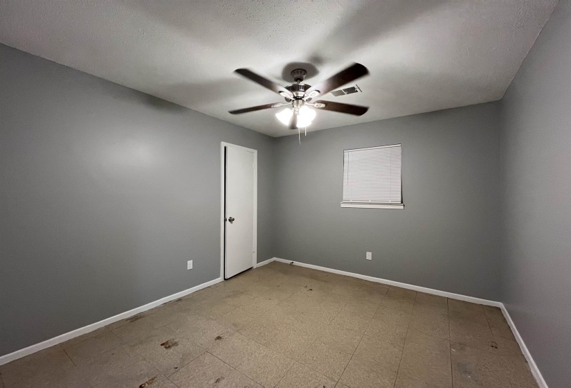 Empty room with ceiling fan and baseboards