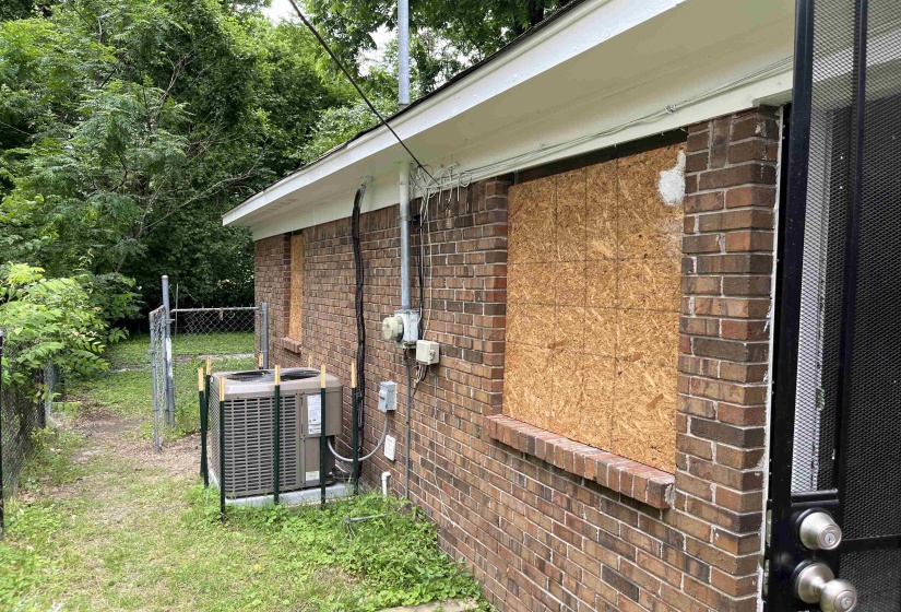 Exterior view of brick siding and a cooling unit