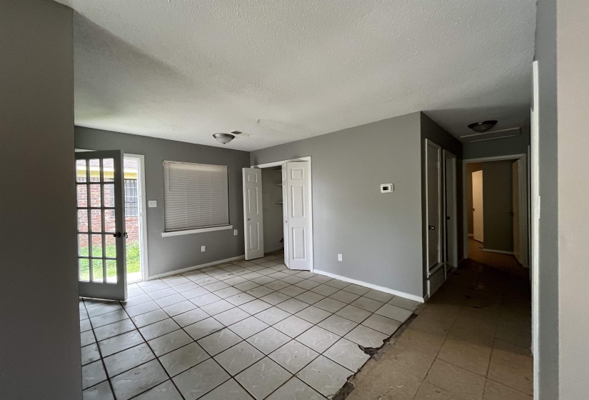 Unfurnished bedroom featuring a textured ceiling, light tile patterned floors, and a closet