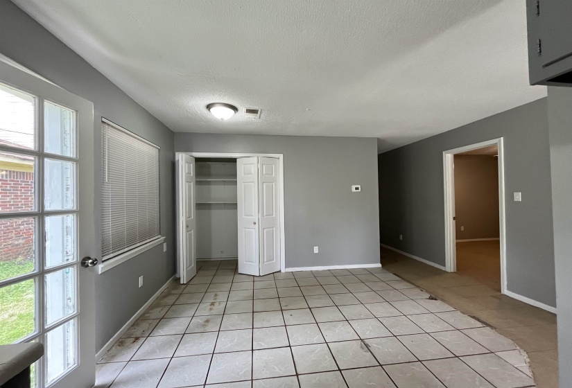 Unfurnished bedroom featuring light tile patterned floors, a textured ceiling, and a closet