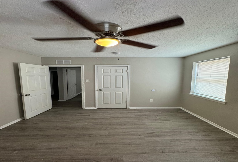 Room featuring wood-finish flooring, neutral wall tones, and white trim
