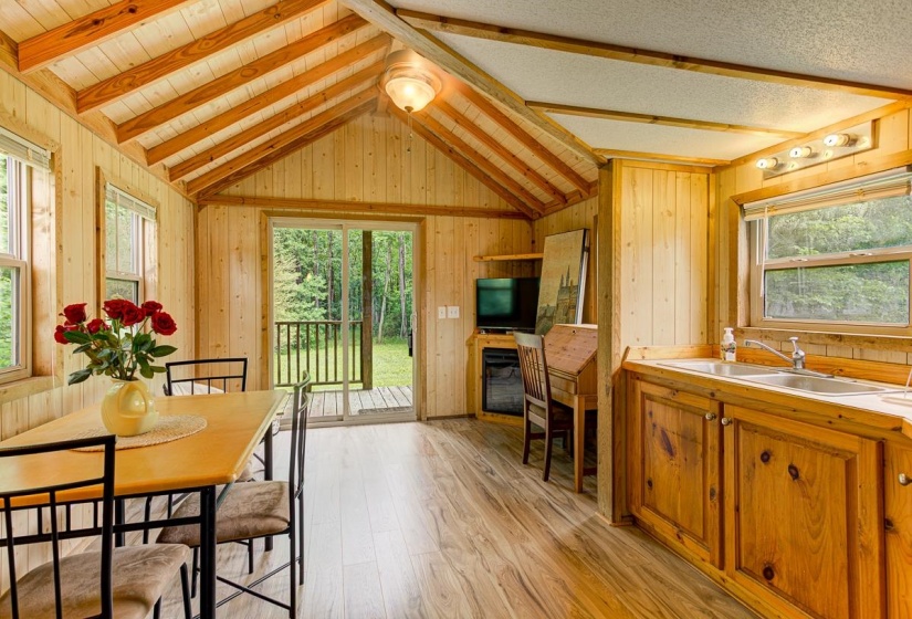 Vaulted wood-paneled ceiling with exposed beams, wood-finish flooring, and natural wood wall paneling throughout