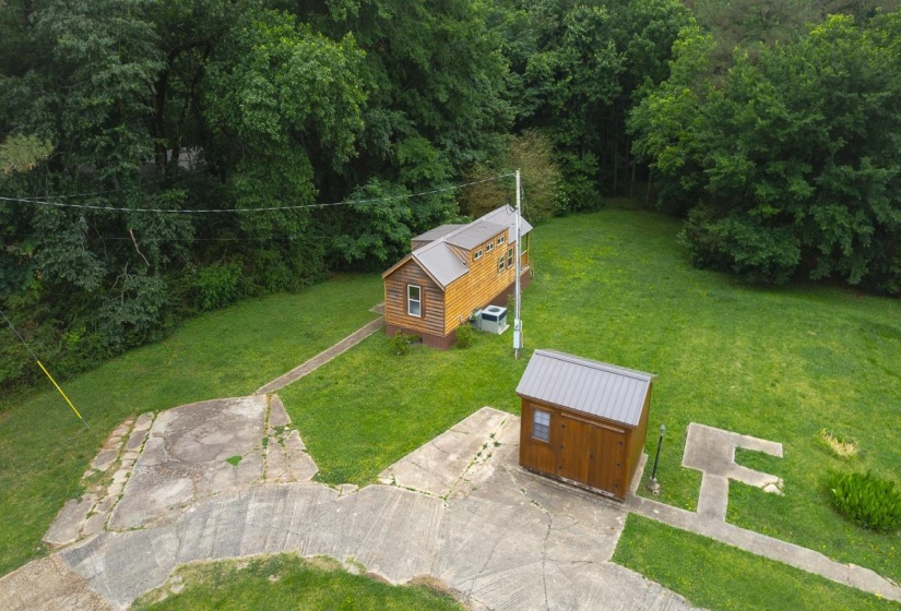 Wood-sided home with a metal roof and an accompanying wood-sided shed