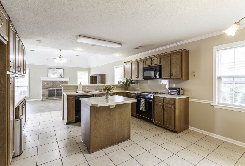 Kitchen featuring wood-finish cabinetry, tile flooring, and a central island