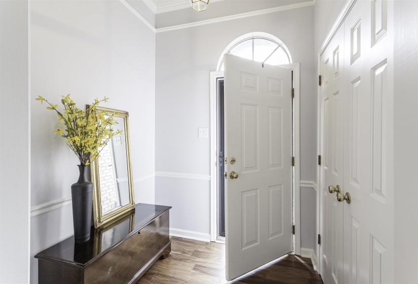 Entryway featuring wood-finish flooring and a paneled front door with an arched transom