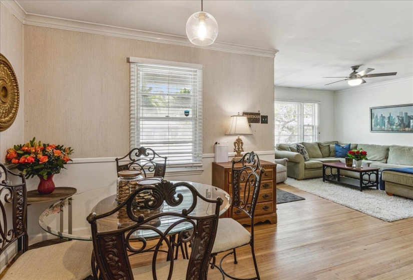 Dining area with a glass-top table, decorative metal chairs, and a contemporary pendant light fixture