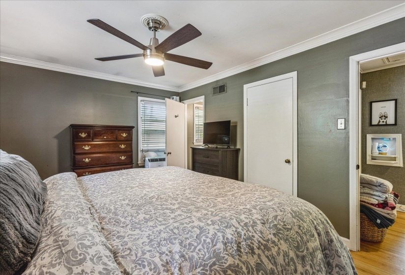 Spacious interior room featuring a ceiling fan with integrated lighting, crown molding, and painted walls