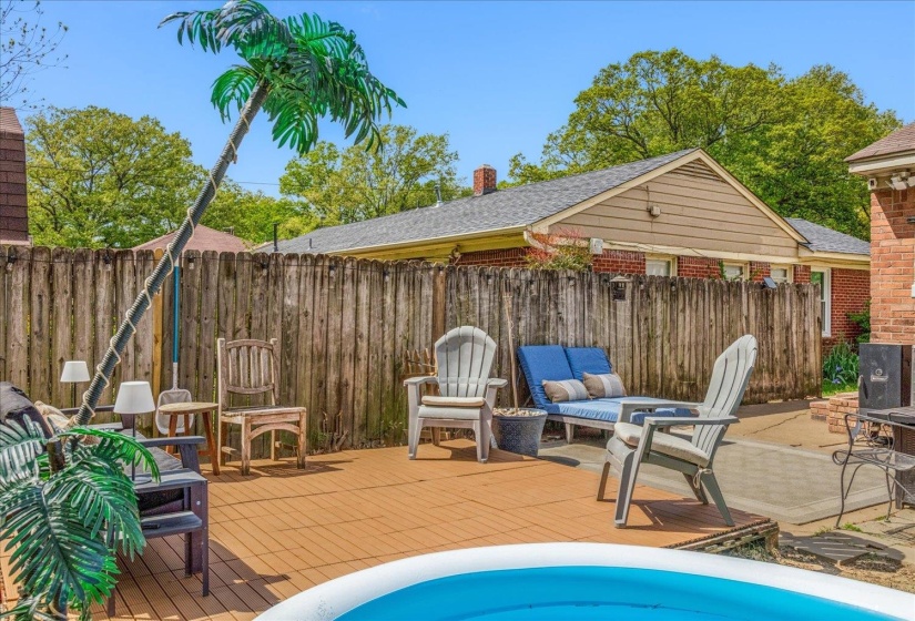Expansive backyard deck featuring wood-finish flooring, a wood privacy fence, and a designated patio area with stone pavers