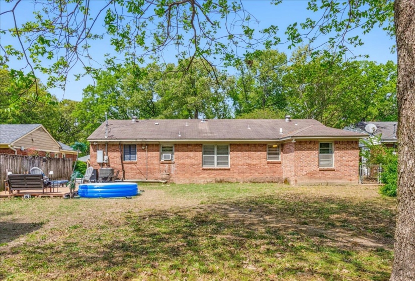 Brick exterior with multiple windows and a wood deck