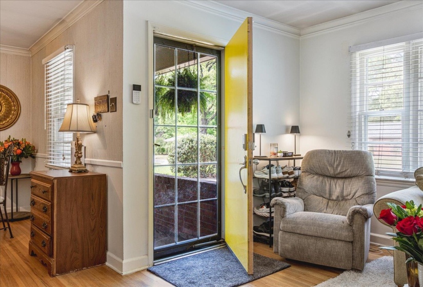 Entryway featuring a bright yellow door with an overhead transom window and a full-light storm door