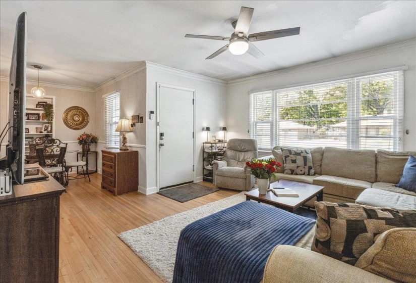 Living area featuring wood-finish flooring and crown molding