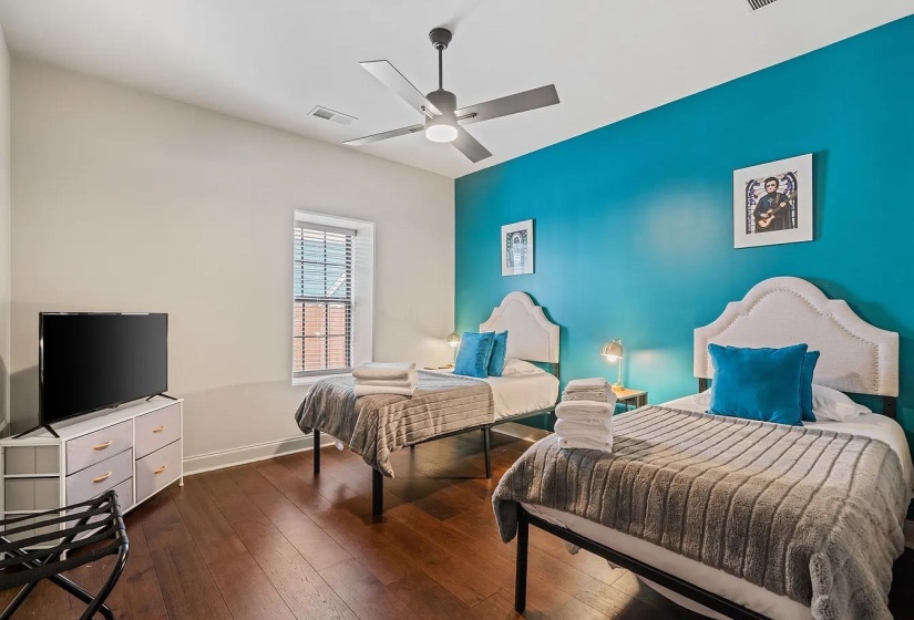 Bedroom with dark wood-type flooring and a ceiling fan