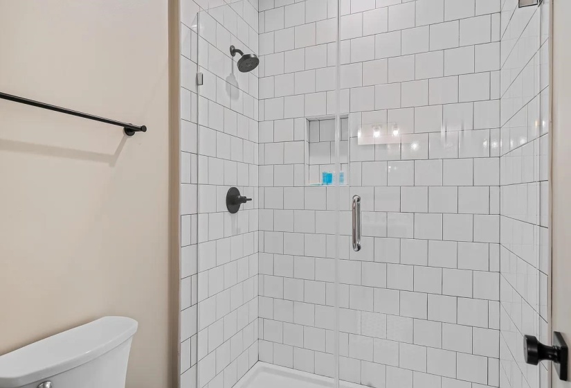 Bathroom with a shower stall and toilet