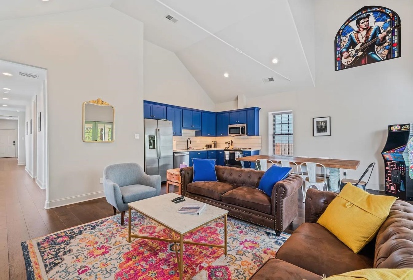 Living area featuring a high ceiling, dark wood-style floors, and recessed lighting