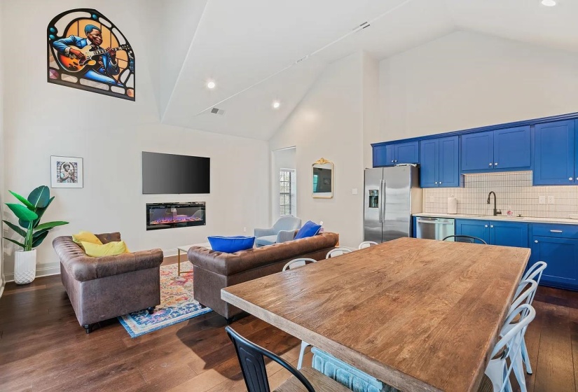 Dining room with recessed lighting, dark wood-style floors, vaulted ceiling, and a glass covered fireplace