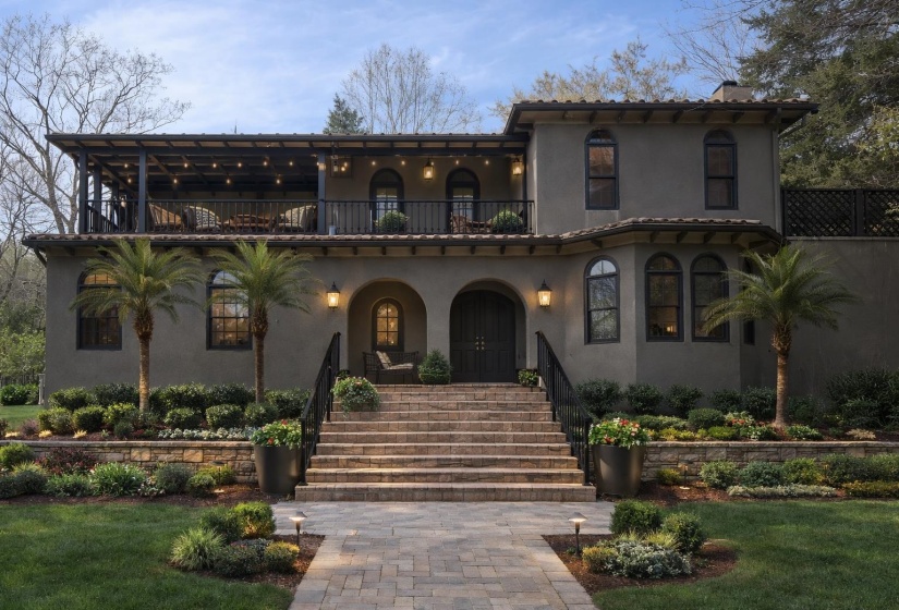 Mediterranean / spanish house featuring stucco siding, covered porch, a balcony, and a front yard
