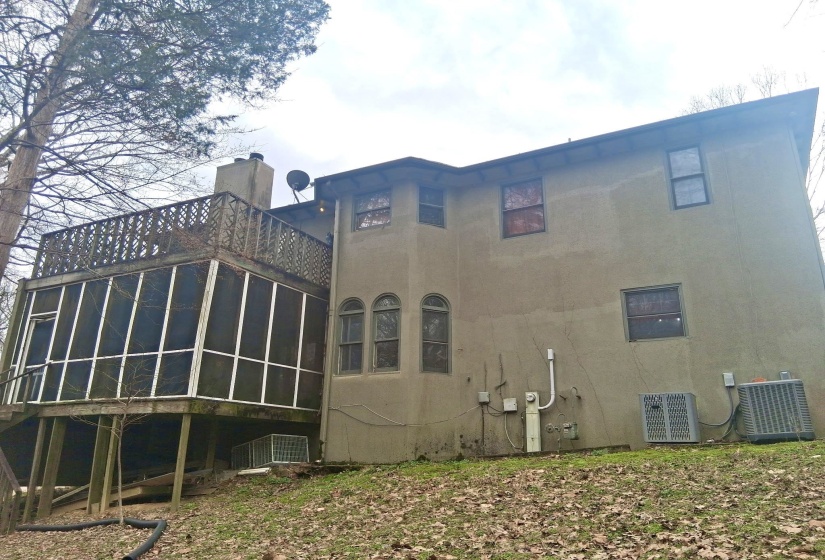 Rear view of property featuring a sunroom and a chimney