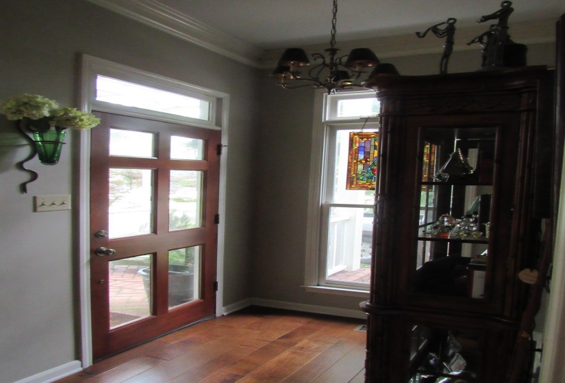 Entryway featuring hardwood flooring, a multi-paneled wood-finish door with transom window, and a coordinated sidelight