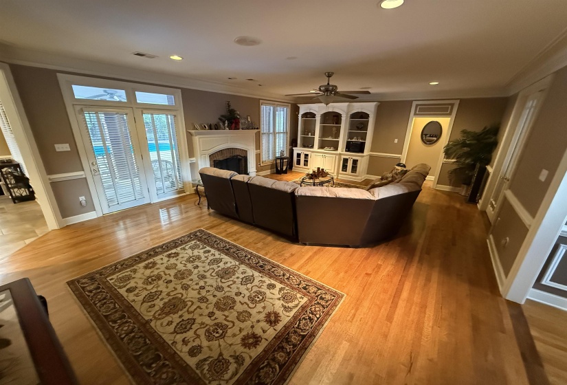 Living area with ornamental molding, a fireplace, light wood finished floors, recessed lighting, and a ceiling fan