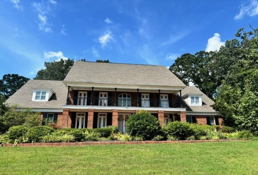 View of front of property featuring a balcony, and brick siding