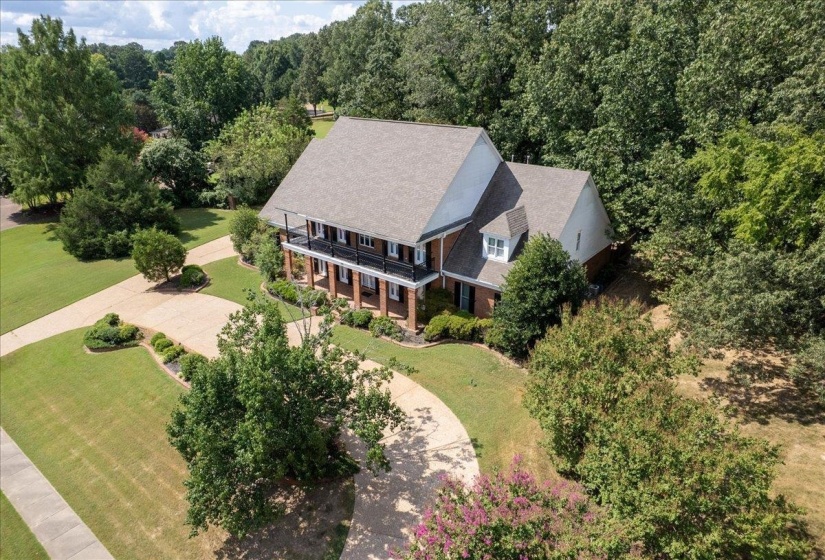 Aerial view of property and surrounding area with a forest