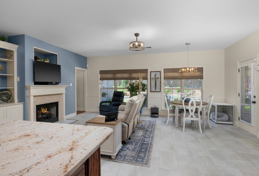 Living area featuring a tile fireplace with mantel and built-in shelving, wood-finish flooring, and crown molding