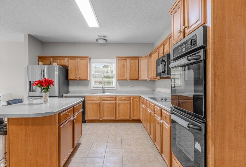 Kitchen featuring wood cabinetry, light-toned countertops, and tile flooring
