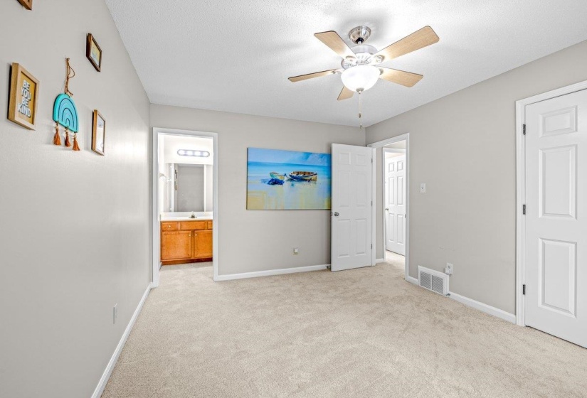 Bedroom featuring light gray wall paint, neutral carpeting, and a ceiling fan with integrated lighting