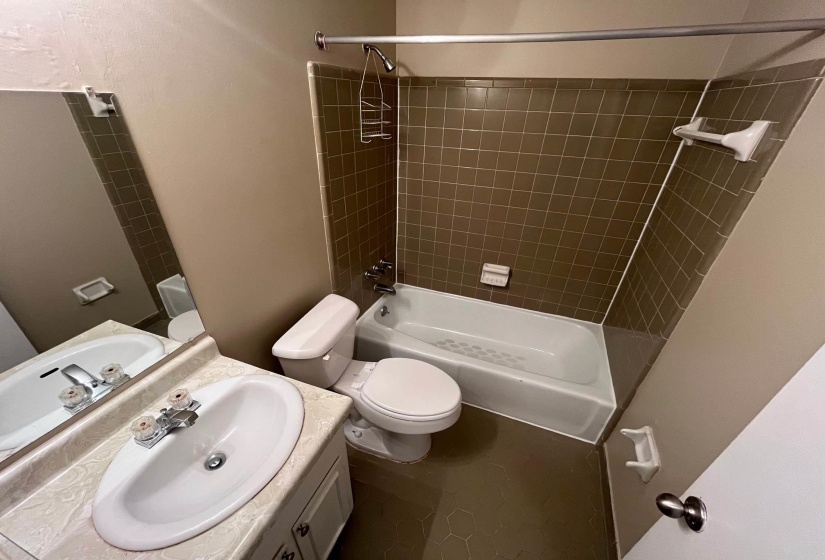 Bathroom featuring a vanity with a laminate countertop, an oval sink, and a two-handle faucet