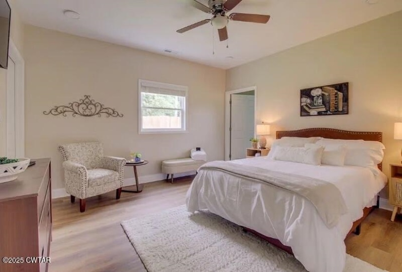 Spacious bedroom with wood-finish flooring, a ceiling fan, and recessed lighting