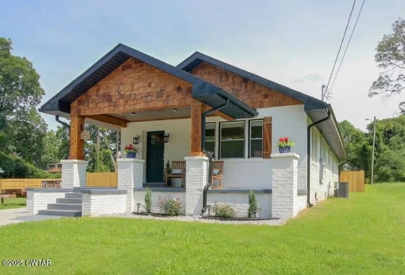 Contemporary home with a gabled roofline, featuring cedar shake siding and a covered front porch