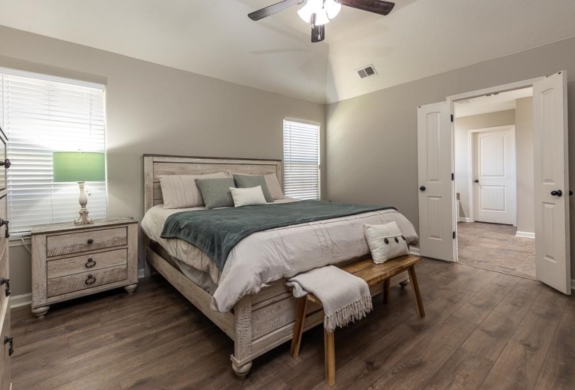 Spacious room featuring vaulted ceilings, wood-finish flooring, and white trim