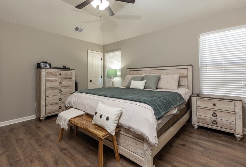 Spacious room featuring vaulted ceilings, wood-finish flooring, and white window blinds