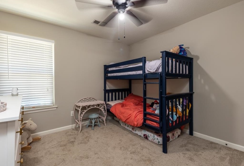 Carpeted room featuring a ceiling fan with integrated lighting, a window with horizontal blinds, and neutral wall tones