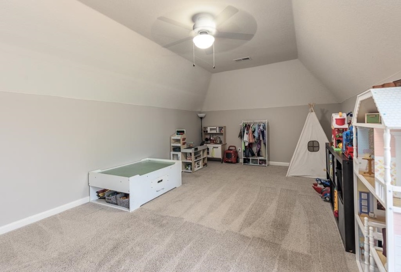 Carpeted bonus room with a vaulted ceiling and a ceiling fan