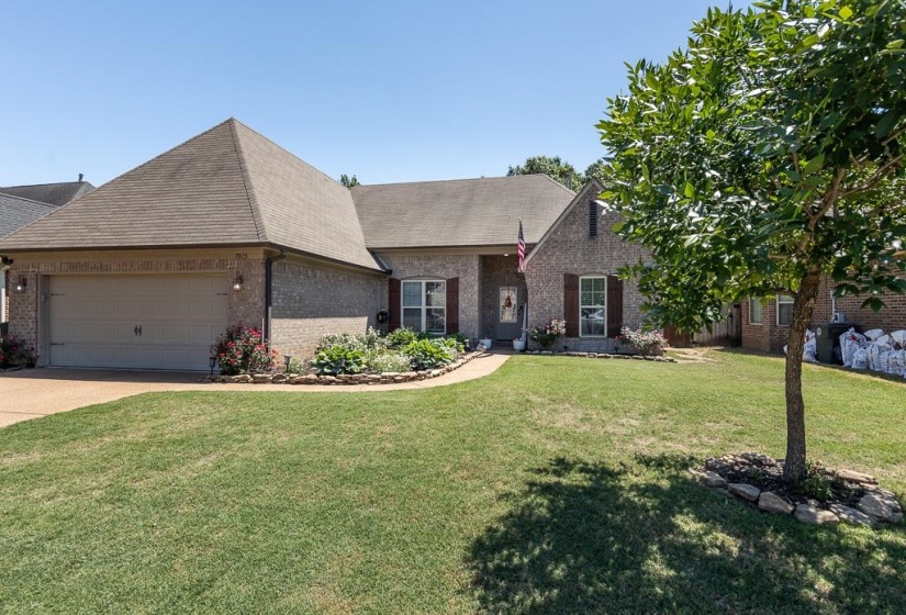 Brick exterior with a gabled roofline, an attached two-car garage, and a concrete driveway