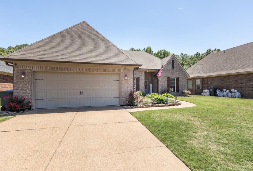 Brick exterior with a peaked roofline and a two-car garage