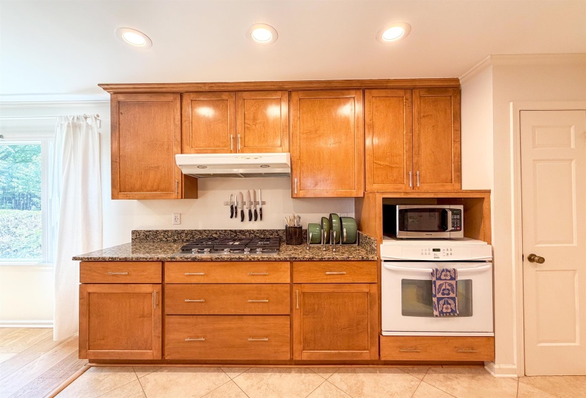 Kitchen featuring wood cabinetry, granite-style countertops, a gas cooktop, and a built-in wall oven