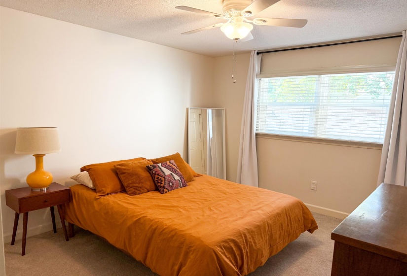 Carpeted room featuring a ceiling fan with integrated lighting, a window with blinds, and white baseboards